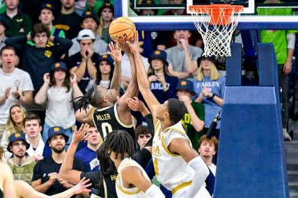 Feb 27, 2024; South Bend, Indiana, USA; Wake Forest Demon Deacons guard Kevin Miller (0) goes up for a shot as Notre Dame Fighting Irish forward Kebba Njie (14) defends in the second half at the Purcell Pavilion. Mandatory Credit: Matt Cashore-USA TODAY Sports
