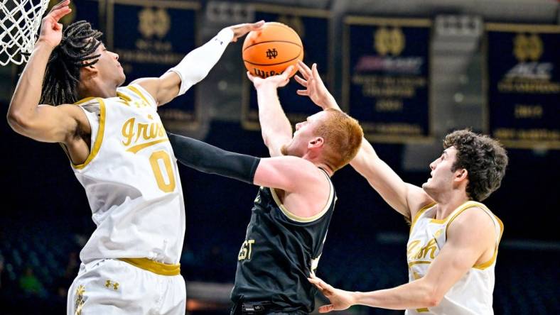 Feb 27, 2024; South Bend, Indiana, USA; Wake Forest Demon Deacons guard Cameron Hildreth (2) goes up for a shot as Notre Dame Fighting Irish forward Carey Booth (0) and guard Logan Imes (2) defend in the second half at the Purcell Pavilion. Mandatory Credit: Matt Cashore-USA TODAY Sports