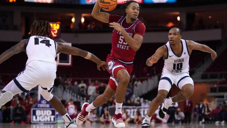 Feb 27, 2024; Fresno, California, USA; Fresno State Bulldogs guard Xavier DuSell (53) drives past Utah State Aggies guard Josh Uduje (14) and guard Darius Brown II (10) in overtime at the Save Mart Center. Mandatory Credit: Cary Edmondson-USA TODAY Sports