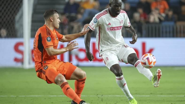 Feb 27, 2024; Houston, TX, USA; St. Louis CITY SC forward Samuel Adeniran (16) attempts to control the ball as Houston Dynamo FC defender Erik Sviatchenko (28) defends during the second half at Shell Energy Stadium. Mandatory Credit: Troy Taormina-USA TODAY Sports