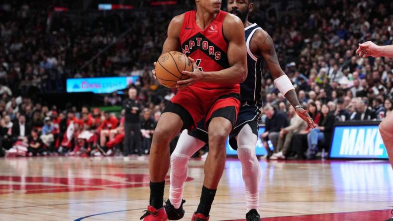 Feb 28, 2024; Toronto, Ontario, CAN; Toronto Raptors forward Scottie Barnes (4) controls the ball as Dallas Mavericks guard Kyrie Irving (11) tries to defend during the fourth quarter at Scotiabank Arena. Mandatory Credit: Nick Turchiaro-USA TODAY Sports