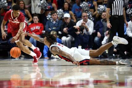 Feb 28, 2024; Oxford, Mississippi, USA; Mississippi Rebels guard Allen Flanigan (7) dives for a loose ball as Alabama Crimson Tide guard Rylan Griffen (3) scoops it up during the first half at The Sandy and John Black Pavilion at Ole Miss. Mandatory Credit: Petre Thomas-USA TODAY Sports