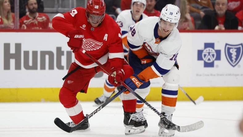 Feb 29, 2024; Detroit, Michigan, USA;  Detroit Red Wings center Andrew Copp (18) and New York Islanders left wing Pierre Engvall (18) battle for the puck in the third period at Little Caesars Arena. Mandatory Credit: Rick Osentoski-USA TODAY Sports