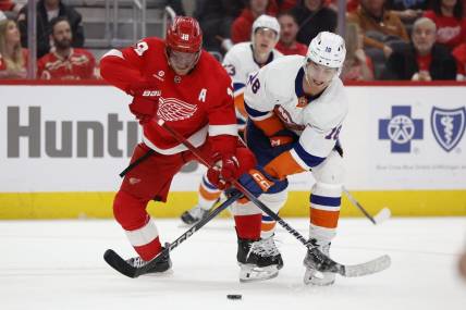Feb 29, 2024; Detroit, Michigan, USA;  Detroit Red Wings center Andrew Copp (18) and New York Islanders left wing Pierre Engvall (18) battle for the puck in the third period at Little Caesars Arena. Mandatory Credit: Rick Osentoski-USA TODAY Sports