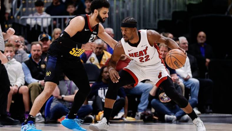 Feb 29, 2024; Denver, Colorado, USA; Miami Heat forward Jimmy Butler (22) controls the ball as Denver Nuggets guard Jamal Murray (27) guards in the first quarter at Ball Arena. Mandatory Credit: Isaiah J. Downing-USA TODAY Sports