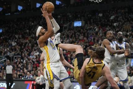 Mar 1, 2024; Toronto, Ontario, CAN; Golden State Warriors guard Moses Moody (4) comes down with a rebound as Toronto Raptors forward Kelly Olynyk (41) falls to the court during the first half at Scotiabank Arena. Mandatory Credit: John E. Sokolowski-USA TODAY Sports