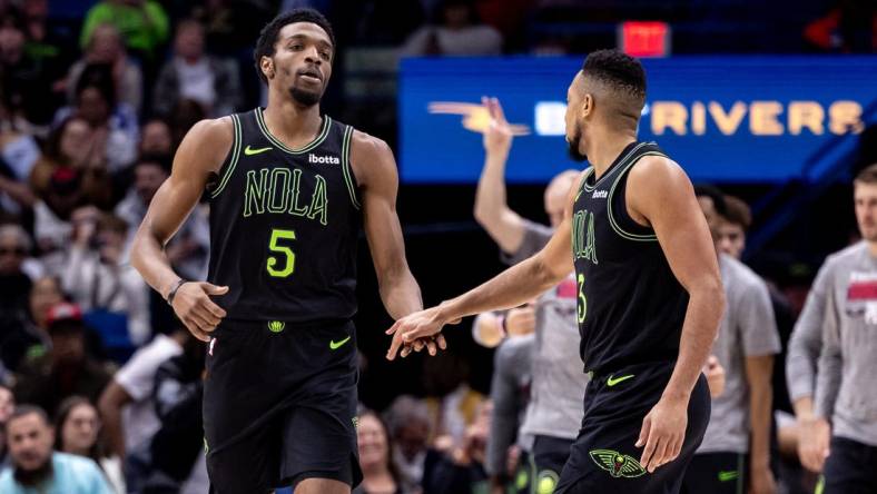 Mar 1, 2024; New Orleans, Louisiana, USA;  New Orleans Pelicans forward Herbert Jones (5) slaps hands with guard CJ McCollum (3) after a play against the Indiana Pacers during the first half at Smoothie King Center. Mandatory Credit: Stephen Lew-USA TODAY Sports