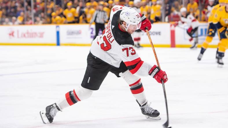 Feb 13, 2024; Nashville, Tennessee, USA;  New Jersey Devils right wing Tyler Toffoli (73) takes a shot on goal against the Nashville Predators during the second period at Bridgestone Arena. Mandatory Credit: Steve Roberts-USA TODAY Sports