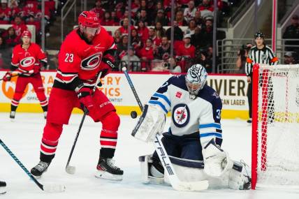 Mar 2, 2024; Raleigh, North Carolina, USA; Winnipeg Jets goaltender Connor Hellebuyck (37) makes a save in front of Carolina Hurricanes right wing Stefan Noesen (23) during the first period at PNC Arena. Mandatory Credit: James Guillory-USA TODAY Sports