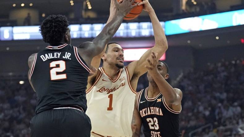 Mar 2, 2024; Austin, Texas, USA; Texas Longhorns forward Dylan Disu (1) drives to the basket while defended by Oklahoma State Cowboys center Brandon Garrison (23) and guard Eric Dailey Jr. (2) during the first half at Moody Center. Mandatory Credit: Scott Wachter-USA TODAY Sports