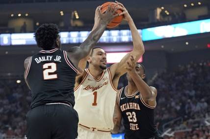 Mar 2, 2024; Austin, Texas, USA; Texas Longhorns forward Dylan Disu (1) drives to the basket while defended by Oklahoma State Cowboys center Brandon Garrison (23) and guard Eric Dailey Jr. (2) during the first half at Moody Center. Mandatory Credit: Scott Wachter-USA TODAY Sports