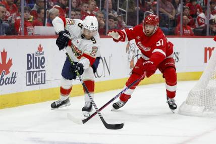 Mar 2, 2024; Detroit, Michigan, USA; Florida Panthers center Sam Bennett (9) and Detroit Red Wings left wing J.T. Compher (37) battle for the puck in the first period at Little Caesars Arena. Mandatory Credit: Rick Osentoski-USA TODAY Sports