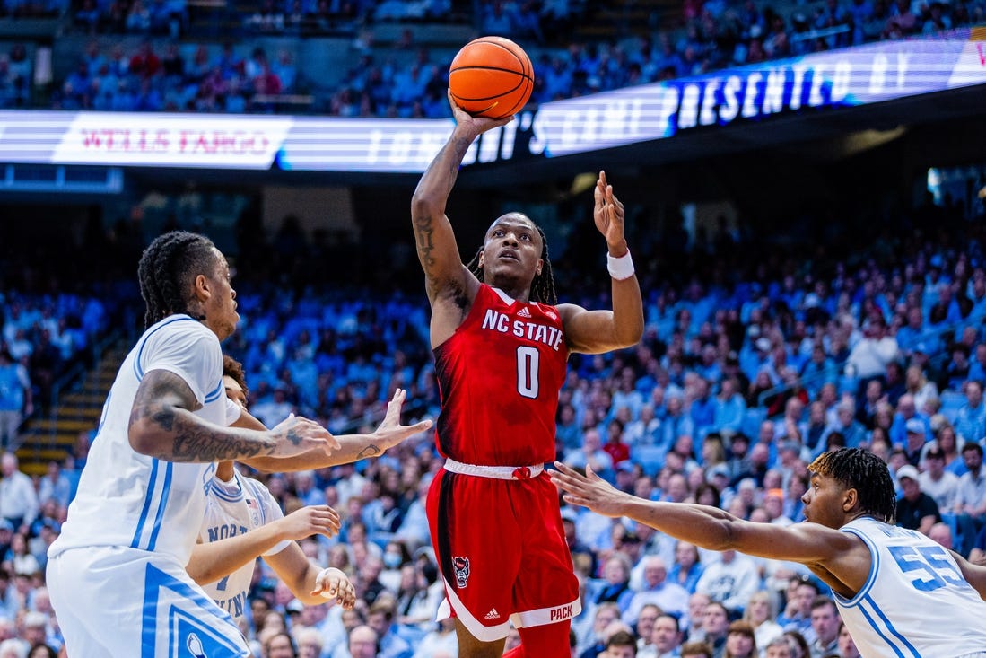 Mar 2, 2024; Chapel Hill, North Carolina, USA; North Carolina State Wolfpack guard DJ Horne (0) shoots between North Carolina Tar Heels forward Armando Bacot (5) (left) and forward Harrison Ingram (55) during the first half at Dean E. Smith Center. Mandatory Credit: Scott Kinser-USA TODAY Sports