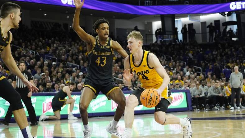 Mar 2, 2024; Evanston, Illinois, USA; Northwestern Wildcats guard Blake Smith (43) defends Iowa Hawkeyes guard Josh Dix (4) during the first half at Welsh-Ryan Arena. Mandatory Credit: David Banks-USA TODAY Sports