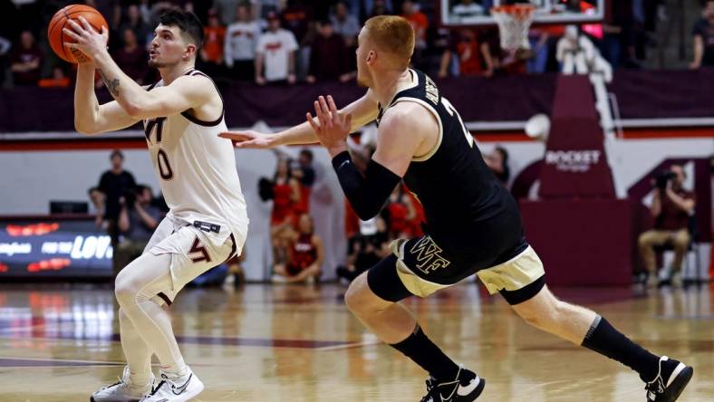 Mar 2, 2024; Blacksburg, Virginia, USA; Virginia Tech Hokies guard Hunter Cattoor (0) shoots the ball against Wake Forest Demon Deacons guard Cameron Hildreth (2) during the second half at Cassell Coliseum. Mandatory Credit: Peter Casey-USA TODAY Sports