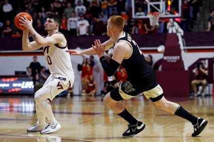 Mar 2, 2024; Blacksburg, Virginia, USA; Virginia Tech Hokies guard Hunter Cattoor (0) shoots the ball against Wake Forest Demon Deacons guard Cameron Hildreth (2) during the second half at Cassell Coliseum. Mandatory Credit: Peter Casey-USA TODAY Sports