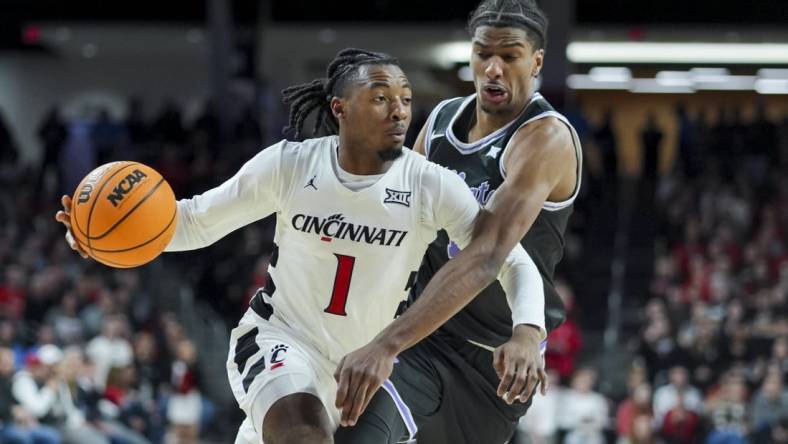 Mar 2, 2024; Cincinnati, Ohio, USA;  Cincinnati Bearcats guard Day Day Thomas drives to the basket against Kansas State Wildcats forward David N'Guessan (1) in the first half at Fifth Third Arena. Mandatory Credit: Aaron Doster-USA TODAY Sports