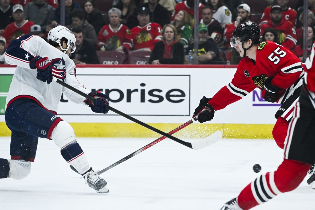 Mar 2, 2024; Chicago, Illinois, USA;  Columbus Blue Jackets center Cole Sillinger (4) shoots the puck against Chicago Blackhawks defenseman Kevin Korchinski (55) during the first period at the  United Center. Mandatory Credit: Matt Marton-USA TODAY Sports