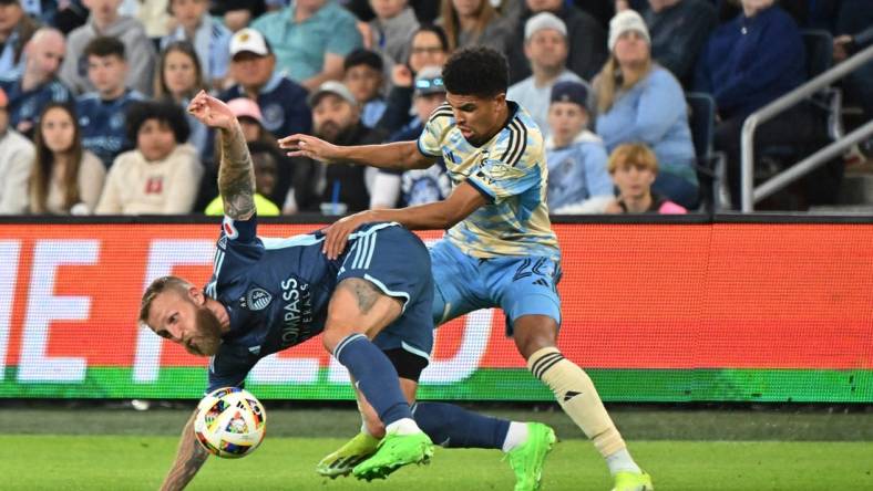 Mar 2, 2024; Kansas City, Kansas, USA; Sporting Kansas City forward Johnny Russell (7) battles Philadelphia Union defender Nathan Harriel (26) for the ball in the first half at Children's Mercy Park. Mandatory Credit: Peter Aiken-USA TODAY Sports