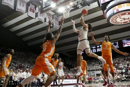 Mar 2, 2024; Tuscaloosa, Alabama, USA; Alabama guard Mark Sears (1) scores in the lane as he is defended by Tennessee guard Zakai Zeigler (5) and Tennessee forward Tobe Awaka (11) at Coleman Coliseum. Mandatory Credit: Gary Cosby Jr.-USA TODAY Sports