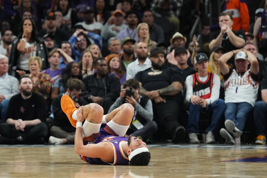 Mar 2, 2024; Phoenix, Arizona, USA; Phoenix Suns guard Devin Booker (1) reacts after being inured against the Houston Rockets during the second half at Footprint Center. Mandatory Credit: Joe Camporeale-USA TODAY Sports