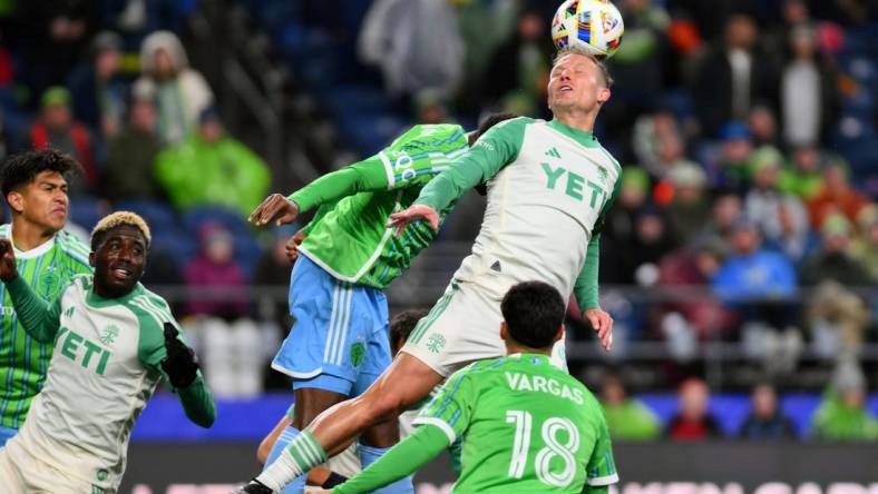 Mar 2, 2024; Seattle, Washington, USA; Austin FC midfielder Alex Ring (8) heads the ball in the second half against the Seattle Sounders FC at Lumen Field. Mandatory Credit: Steven Bisig-USA TODAY Sports