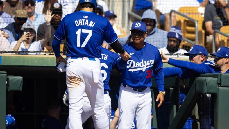 Los Angeles Dodgers designated hitter Shohei Ohtani (17) celebrates with manager Dave Roberts after scoring against the Colorado Rockies during a spring training game at Camelback Ranch-Glendale. Mandatory Credit: Mark J. Rebilas-USA TODAY Sports