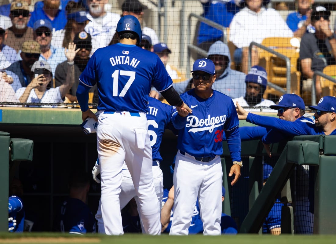 Los Angeles Dodgers designated hitter Shohei Ohtani (17) celebrates with manager Dave Roberts after scoring against the Colorado Rockies during a spring training game at Camelback Ranch-Glendale. Mandatory Credit: Mark J. Rebilas-USA TODAY Sports