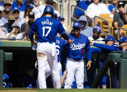 Los Angeles Dodgers designated hitter Shohei Ohtani (17) celebrates with manager Dave Roberts after scoring against the Colorado Rockies during a spring training game at Camelback Ranch-Glendale. Mandatory Credit: Mark J. Rebilas-USA TODAY Sports