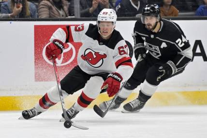 Mar 3, 2024; Los Angeles, California, USA; New Jersey Devils left wing Jesper Bratt (63) keeps the puck away from Los Angeles Kings center Phillip Danault (24) in the second period at Crypto.com Arena. Mandatory Credit: Jayne Kamin-Oncea-USA TODAY Sports