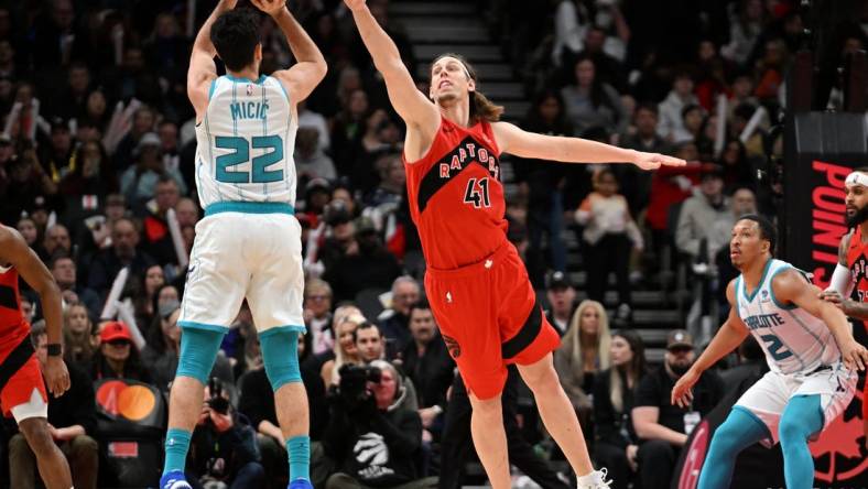 Mar 3, 2024; Toronto, Ontario, CAN;  Charlotte Hornets guard Vasa Micic (22) shoots the ball as Toronto Raptors center Kelly Olynyk (41) defends in the first half at Scotiabank Arena. Mandatory Credit: Dan Hamilton-USA TODAY Sports