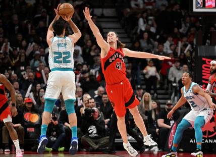 Mar 3, 2024; Toronto, Ontario, CAN;  Charlotte Hornets guard Vasa Micic (22) shoots the ball as Toronto Raptors center Kelly Olynyk (41) defends in the first half at Scotiabank Arena. Mandatory Credit: Dan Hamilton-USA TODAY Sports