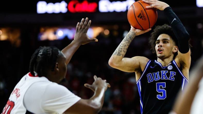 Mar 4, 2024; Raleigh, North Carolina, USA; Duke Blue Devils guard Jeremy Roach (3) shoots the ball past North Carolina State Wolfpack forward DJ Burns Jr. (30) during the first half at PNC Arena. Mandatory Credit: Jaylynn Nash-USA TODAY Sports