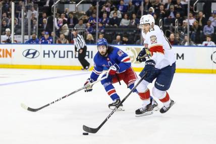 Mar 4, 2024; New York, New York, USA;  New York Rangers center Mika Zibanejad (93) and Florida Panthers center Sam Reinhart (13) chases the puck in the first period at Madison Square Garden. Mandatory Credit: Wendell Cruz-USA TODAY Sports