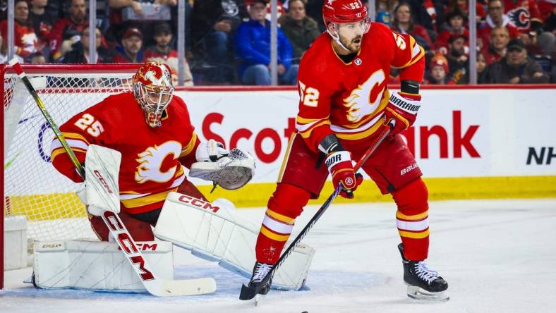 Mar 4, 2024; Calgary, Alberta, CAN; Calgary Flames defenseman MacKenzie Weegar (52) controls the puck in front of Calgary Flames goaltender Jacob Markstrom (25) during the first period against the Seattle Kraken at Scotiabank Saddledome. Mandatory Credit: Sergei Belski-USA TODAY Sports