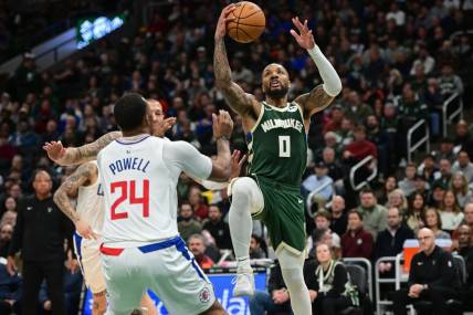 Mar 4, 2024; Milwaukee, Wisconsin, USA;  Milwaukee Bucks guard Damian Lillard (0) takes a shot against Los Angeles Clippers guard Norman Powell (24) in the third quarter at Fiserv Forum. Mandatory Credit: Benny Sieu-USA TODAY Sports