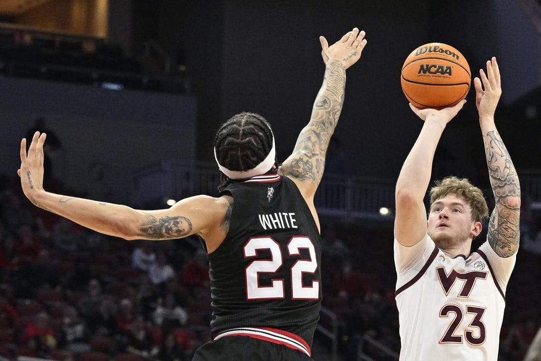 Mar 5, 2024; Louisville, Kentucky, USA; Virginia Tech Hokies guard Tyler Nickel (23) shoots against Louisville Cardinals guard Tre White (22) during the first half at KFC Yum! Center. Mandatory Credit: Jamie Rhodes-USA TODAY Sports