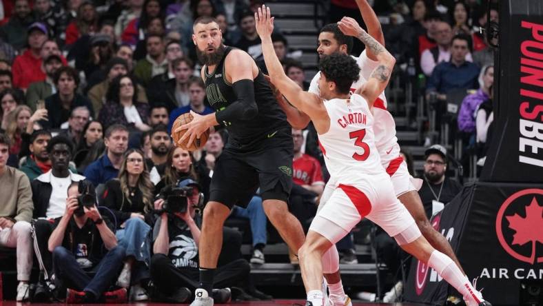 Mar 5, 2024; Toronto, Ontario, CAN; New Orleans Pelicans center Jonas Valanciunas (17) controls the ball as Toronto Raptors guard D.J. Carton (3) tries to defend during the second quarter at Scotiabank Arena. Mandatory Credit: Nick Turchiaro-USA TODAY Sports