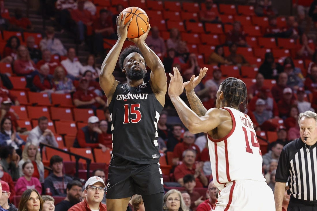 Mar 5, 2024; Norman, Oklahoma, USA; Cincinnati Bearcats forward John Newman III (15) shoots as Oklahoma Sooners forward Jalon Moore (14) defends during the first half at Lloyd Noble Center. Mandatory Credit: Alonzo Adams-USA TODAY Sports