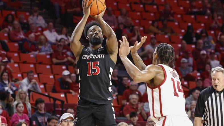 Mar 5, 2024; Norman, Oklahoma, USA; Cincinnati Bearcats forward John Newman III (15) shoots as Oklahoma Sooners forward Jalon Moore (14) defends during the first half at Lloyd Noble Center. Mandatory Credit: Alonzo Adams-USA TODAY Sports