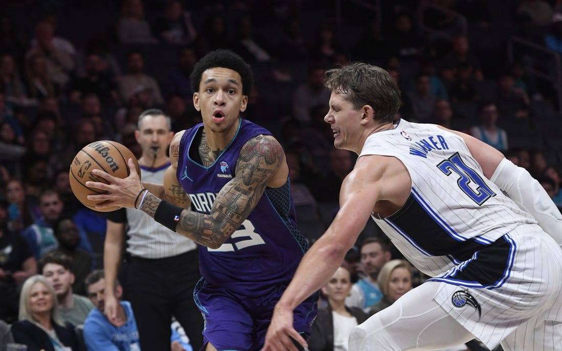 Mar 5, 2024; Charlotte, North Carolina, USA;  Charlotte Hornets guard Tre Mann (23) drives past Orlando Magic center Moritz Wagner (21) during the second half at the Spectrum Center. Mandatory Credit: Sam Sharpe-USA TODAY Sports