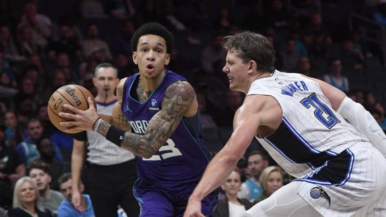 Mar 5, 2024; Charlotte, North Carolina, USA;  Charlotte Hornets guard Tre Mann (23) drives past Orlando Magic center Moritz Wagner (21) during the second half at the Spectrum Center. Mandatory Credit: Sam Sharpe-USA TODAY Sports