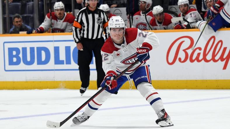 Mar 5, 2024; Nashville, Tennessee, USA; Montreal Canadiens right wing Cole Caufield (22) passes the puck during the second period against the Nashville Predators at Bridgestone Arena. Mandatory Credit: Christopher Hanewinckel-USA TODAY Sports