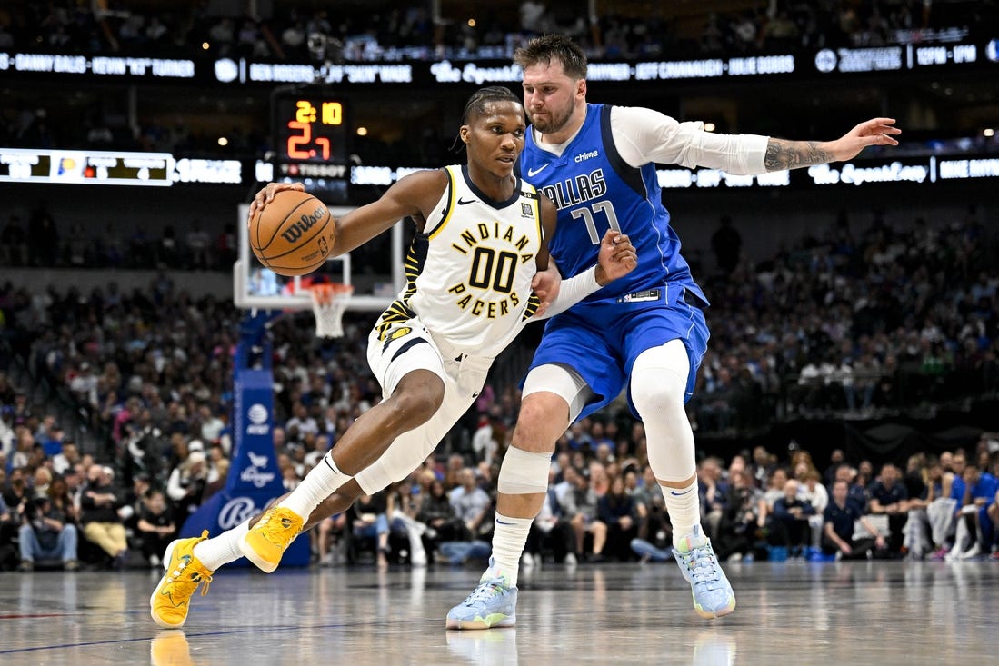 Mar 5, 2024; Dallas, Texas, USA; Indiana Pacers guard Bennedict Mathurin (00) brings the ball up court past Dallas Mavericks guard Luka Doncic (77) during the second half at the American Airlines Center. Mandatory Credit: Jerome Miron-USA TODAY Sports