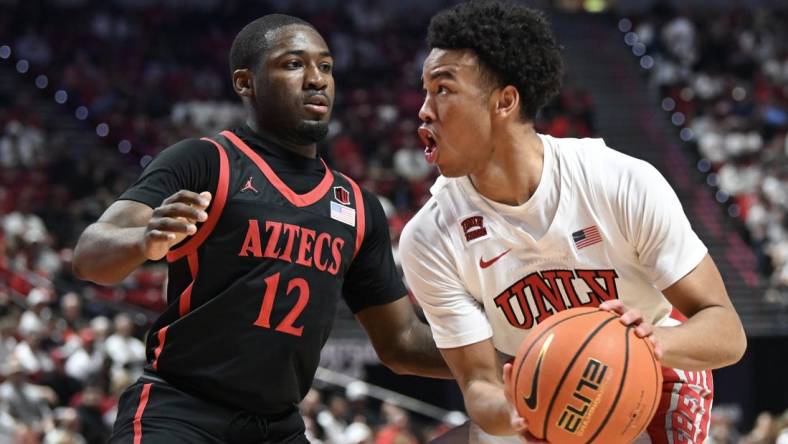 Mar 5, 2024; Las Vegas, Nevada, USA; San Diego State Aztecs guard Darrion Trammell (12) defends against UNLV Rebels guard Dedan Thomas Jr. (11) in the first half at Thomas & Mack Center. Mandatory Credit: Candice Ward-USA TODAY Sports