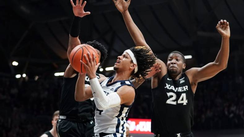 Mar 6, 2024; Indianapolis, Indiana, USA;  Butler Bulldogs guard DJ Davis (4) goes to the basket against Xavier Musketeers guard Dayvion McKnight (20) and Xavier Musketeers forward Abou Ousmane (24) during the first half at Hinkle Fieldhouse. Mandatory Credit: Robert Goddin-USA TODAY Sports