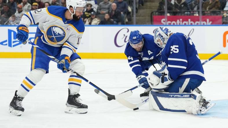 Mar 6, 2024; Toronto, Ontario, CAN; Toronto Maple Leafs defenseman Morgan Rielly (44) battles for the puck with Buffalo Sabres left wing Jordan Greenway (12) in front of goaltender Ilya Samsonov (35) during the second period at Scotiabank Arena. Mandatory Credit: Nick Turchiaro-USA TODAY Sports