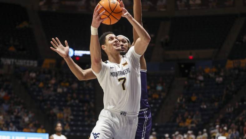 Mar 6, 2024; Morgantown, West Virginia, USA; West Virginia Mountaineers center Jesse Edwards (7) shoots against TCU Horned Frogs forward Xavier Cork (12) during the second half at WVU Coliseum. Mandatory Credit: Ben Queen-USA TODAY Sports