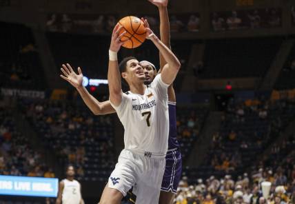 Mar 6, 2024; Morgantown, West Virginia, USA; West Virginia Mountaineers center Jesse Edwards (7) shoots against TCU Horned Frogs forward Xavier Cork (12) during the second half at WVU Coliseum. Mandatory Credit: Ben Queen-USA TODAY Sports