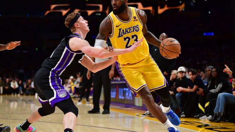 Mar 6, 2024; Los Angeles, California, USA;  Los Angeles Lakers forward LeBron James (23) moves the ball against Sacramento Kings guard Kevin Huerter (9) during the second half at Crypto.com Arena. Mandatory Credit: Gary A. Vasquez-USA TODAY Sports